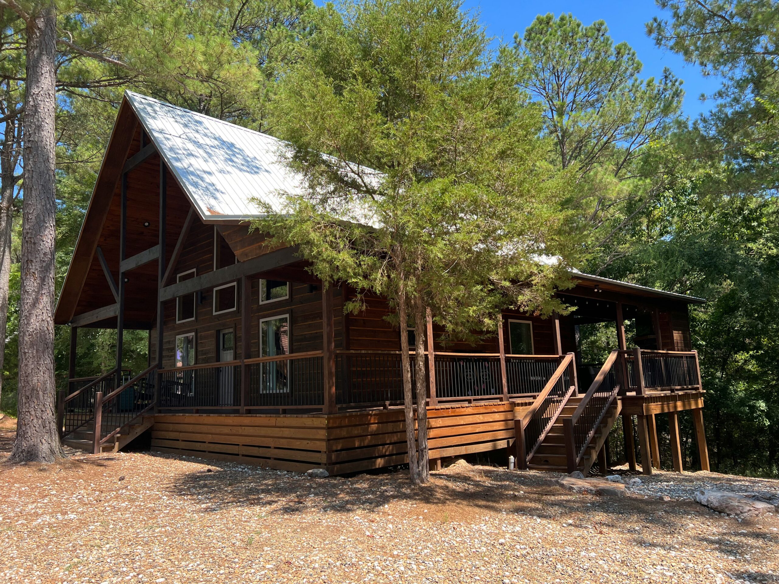 Wooden cabin house surrounded by trees in a forest setting.