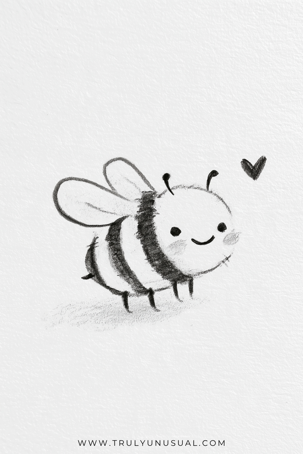 Pencil drawing of a smiling bee angled toward the right, with dark fuzzy stripes across its rounded body and two long oval wings extending upward to the left. Curved antennae, dangling legs, lightly shaded cheeks, and a small dark heart complete the sketch.