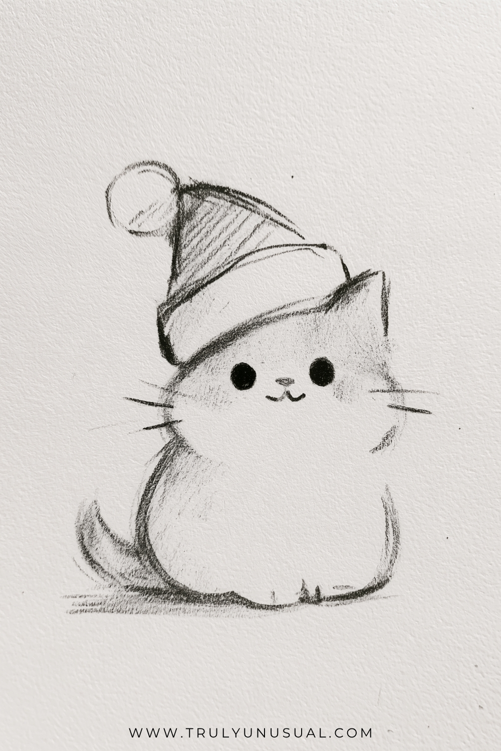 Cute Christmas cat pencil drawing featuring a small, chubby kitten sitting upright and wearing an oversized Santa hat with a fluffy brim and round pom-pom. The cat has pointed ears, large black circular eyes, a tiny smiling mouth, delicate whiskers, and little paws tucked beneath its rounded body. Its curved tail extends to the left, with soft pencil shading adding texture to the fur and hat. Simple black-and-white hand-drawn Christmas illustration on textured white paper, ideal for easy holiday drawing inspiration.